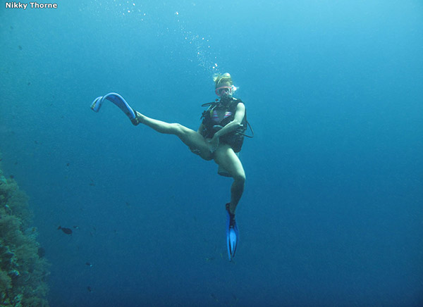 Аквалангистка красуется пилоткой под водой 3 фотография
