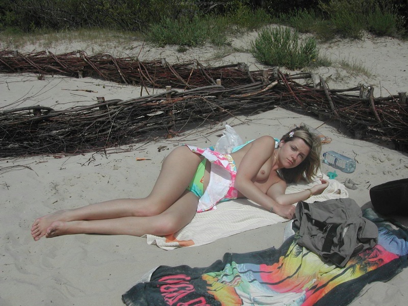 Привлекательная фифа загорает на пляже топлес 13 фотография