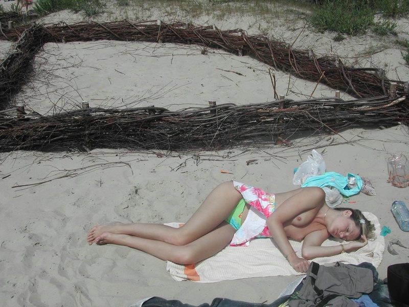 Привлекательная фифа загорает на пляже топлес 12 фотография