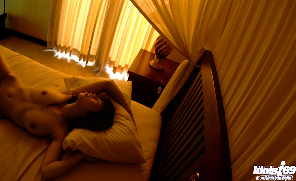 Робкая азиатка извивается голышом на кровати 9 фотография
